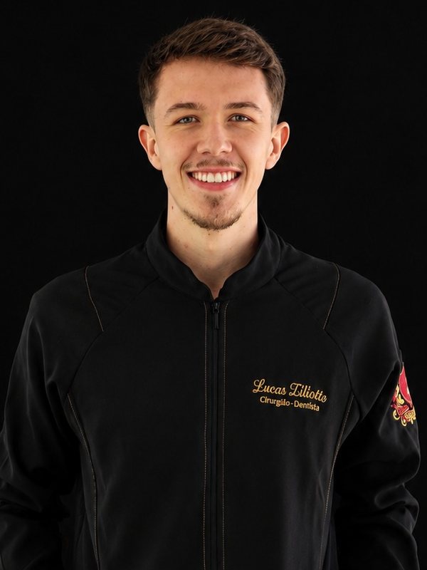 Dr. Lucas Ziliotto, de jaleco preto da clínica, sorrindo