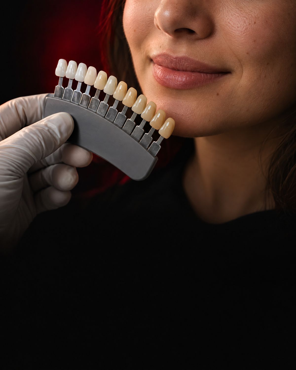Escala de cores de dentes encostada perto dos lábios de uma paciente