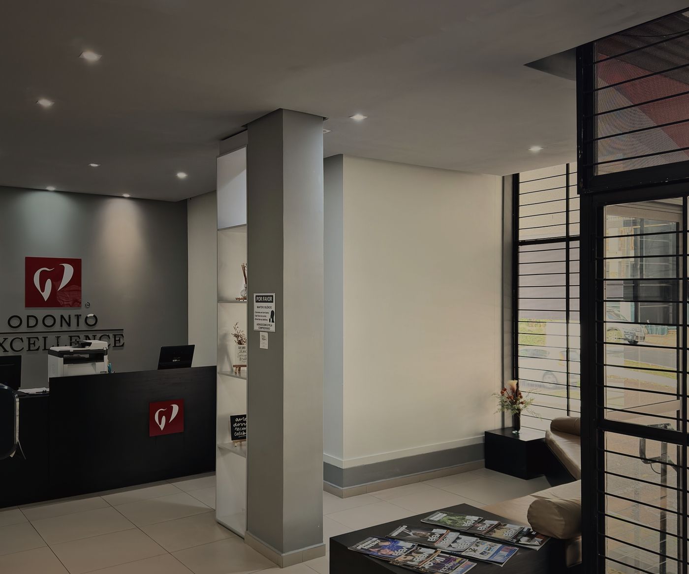 Recepção da Odonto Excellence, com o logo da clínica na parede e o balcão