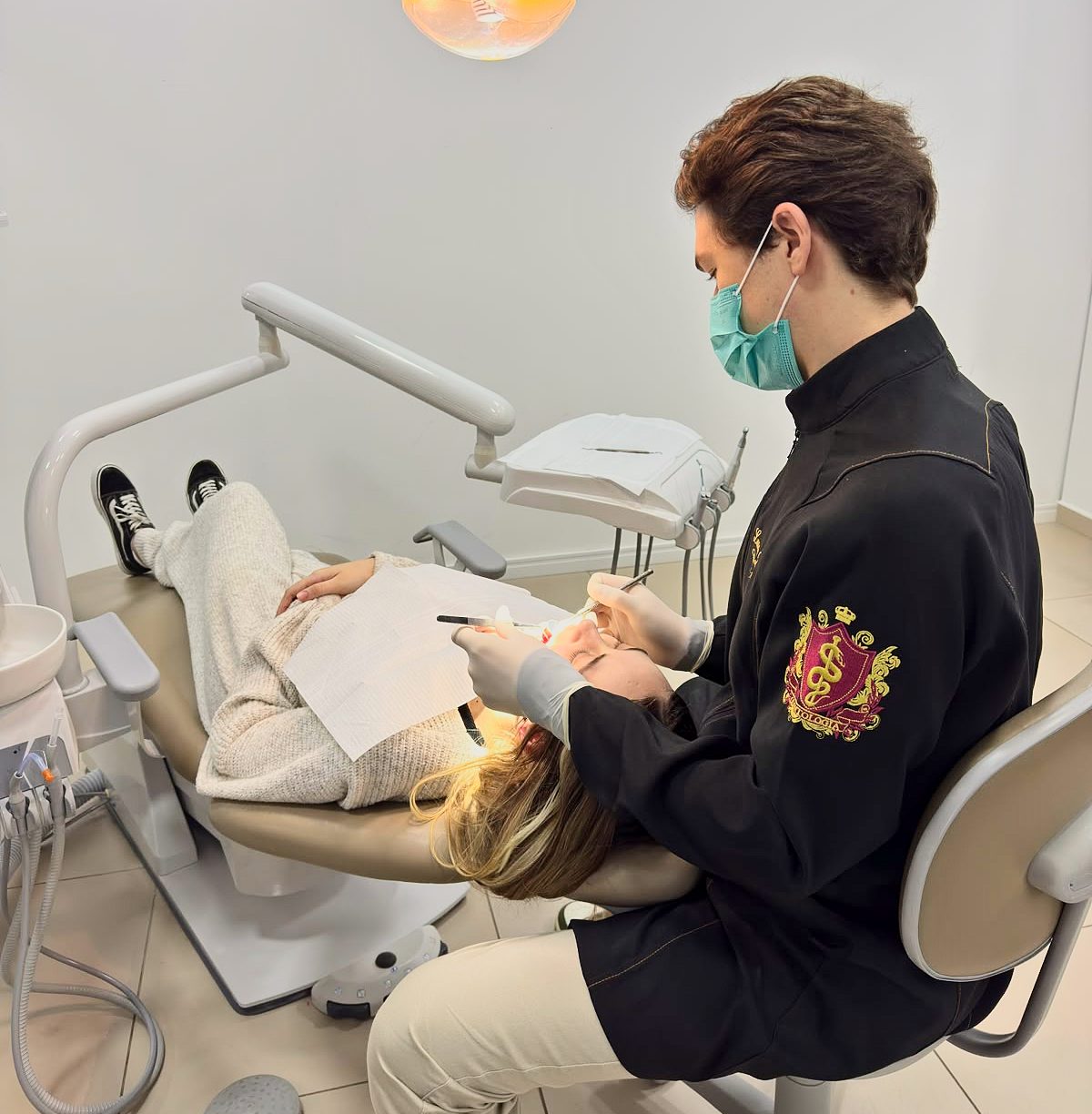 Dentista da clínica atendendo uma paciente na cadeira